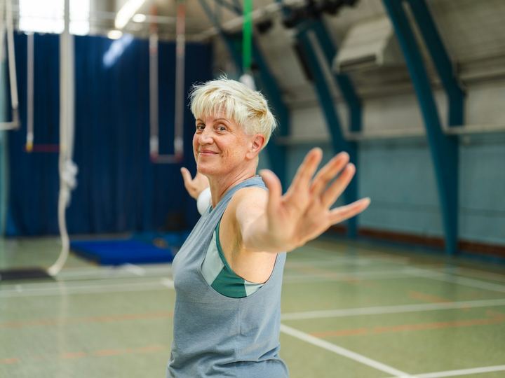 A woman stretching during a movement class in a sports hall