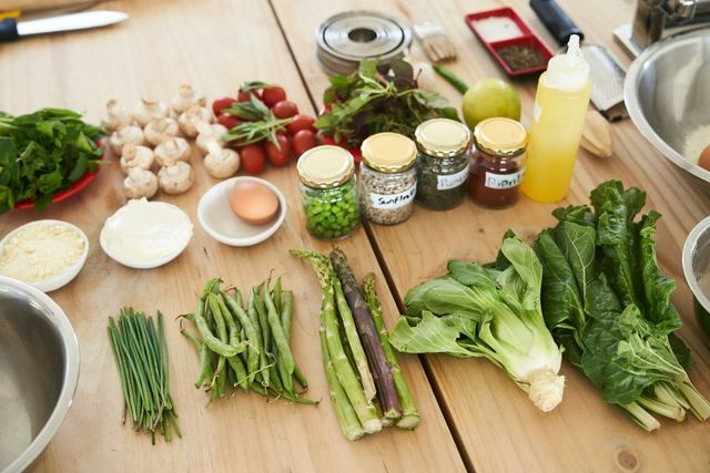 Fresh vegetables, herbs and ingredients laid out on a wooden table